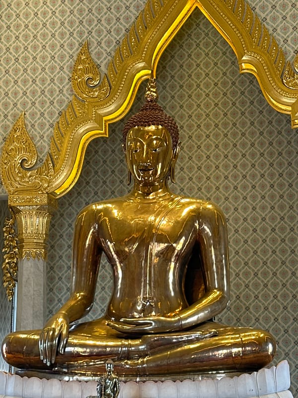 Tourist documents golden Buddha statues at Bangkok temples