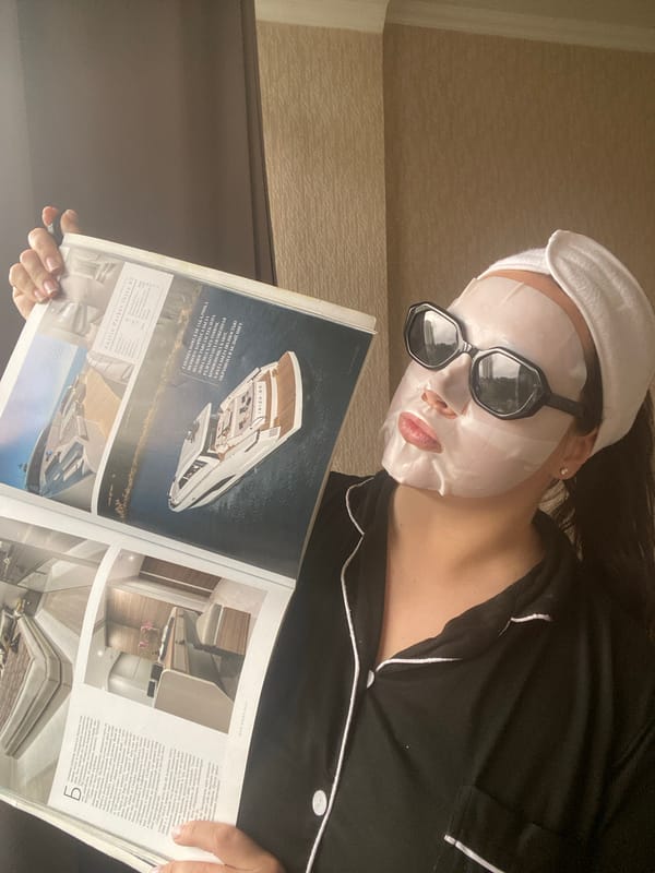 Masked reader enjoys yachting magazines during morning relaxation in Sochi