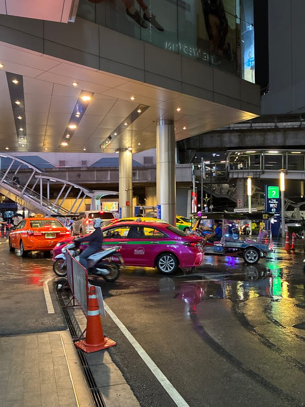 Rainy night traffic and street activity in central Bangkok