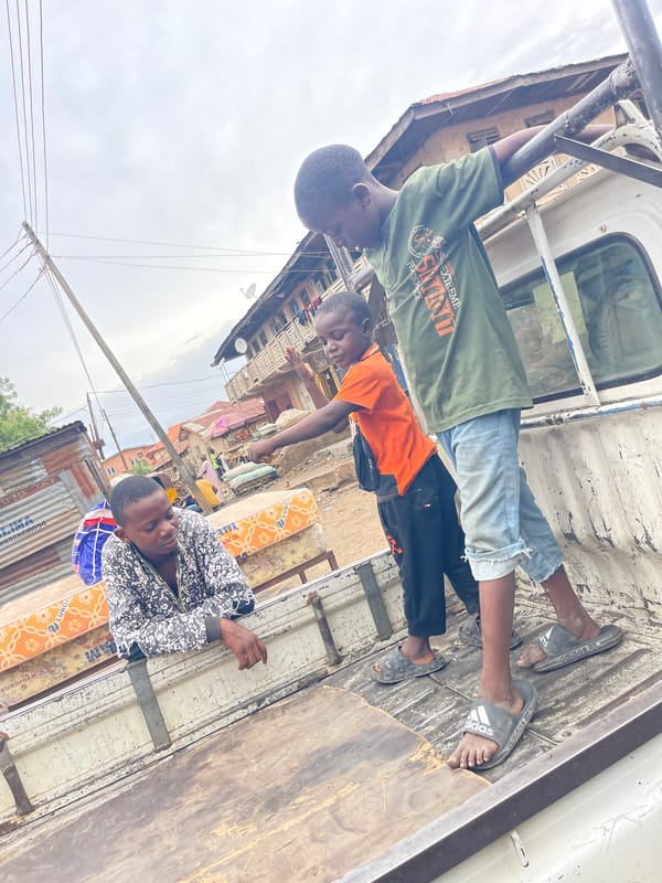 Children ride mattress-loaded pickup truck in Zaria, Nigeria