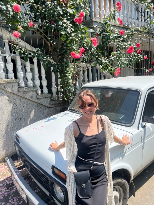 Woman poses by car, meal documented in Batumi