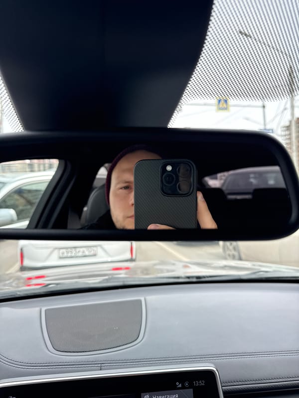 Smartphone user captured in rearview mirror reflection in Krasnoyarsk