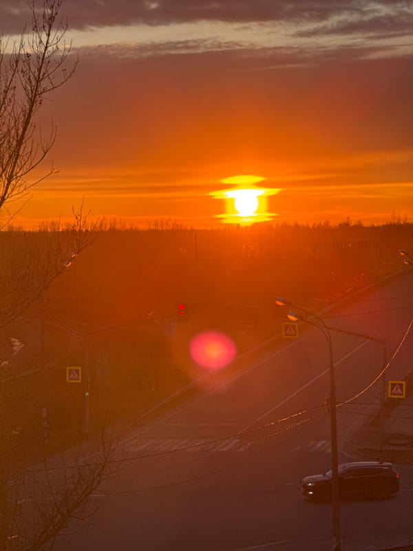 Sunset observed over Ново-Никольское with road traffic visible