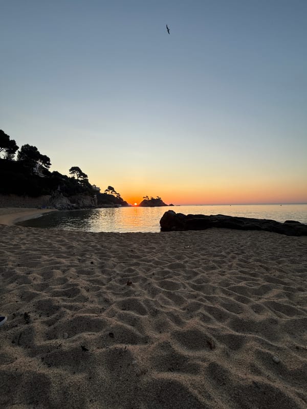 Sunrise over Platja d'Aro's calm Mediterranean shoreline
