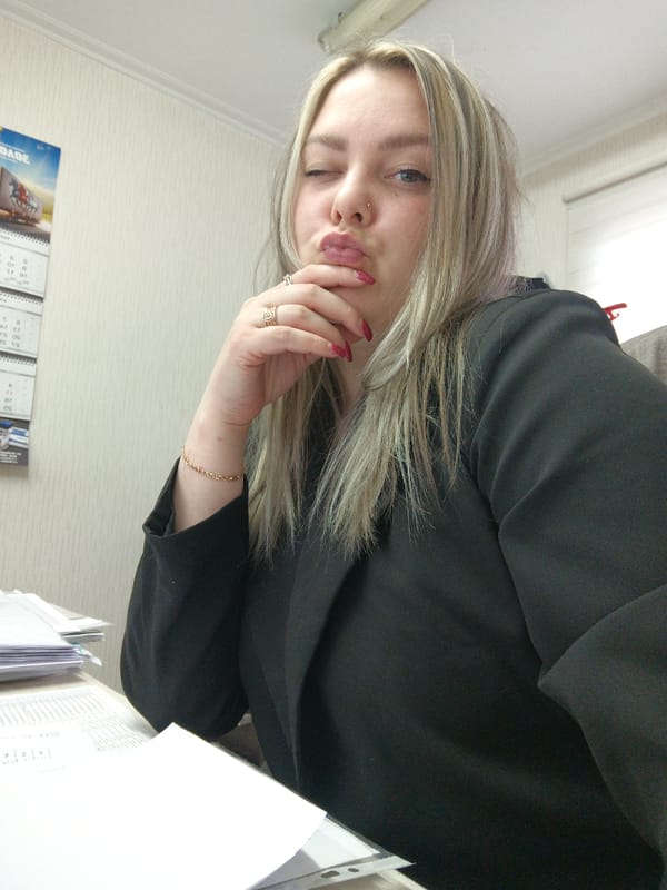 Woman poses playfully at desk in Noviy, Russia