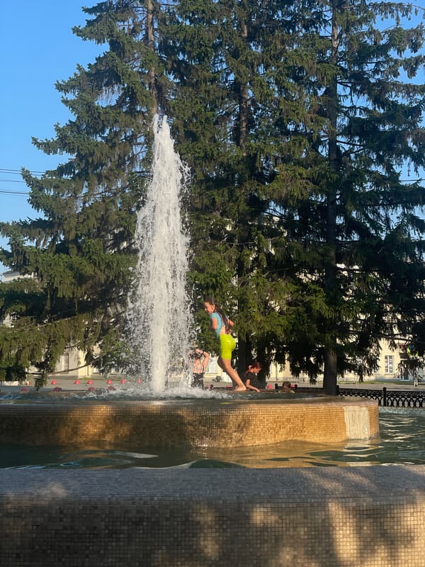 Kids cool off in a city park fountain on a summer day