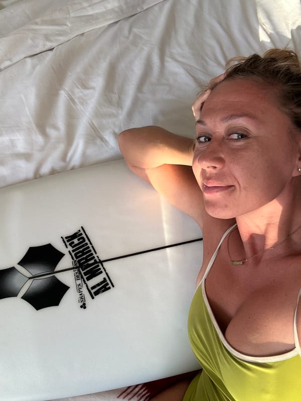 Al Merrick surfboard resting on a bed in North Kuta