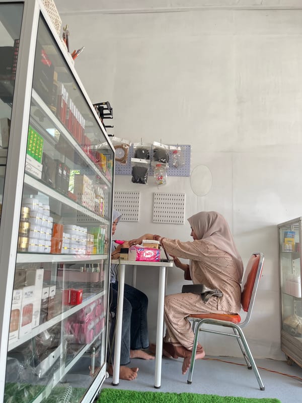 Woman examines display case in Lhokseumawe shop