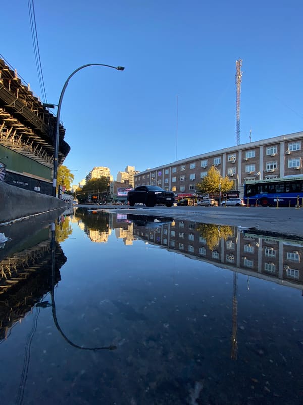 Building reflection captured in Buenos Aires street water