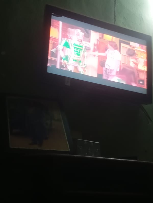 Television displays robot and pajama-clad person scene