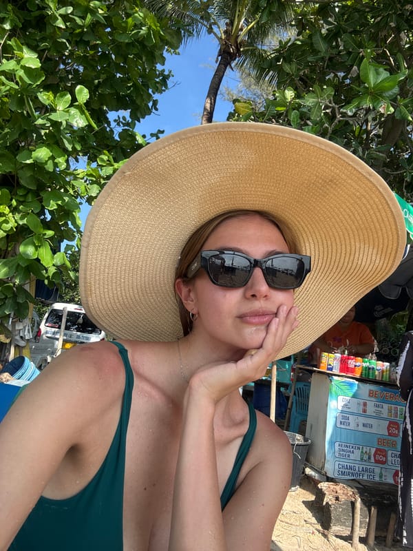 Woman relaxes at Patong beach in green swimsuit