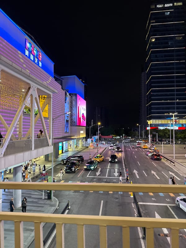 Nighttime entertainment district bustling with shoppers and carnival attractions