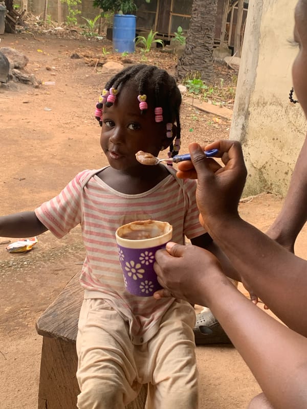Child fed breakfast outdoors in Akwanga, Nigeria