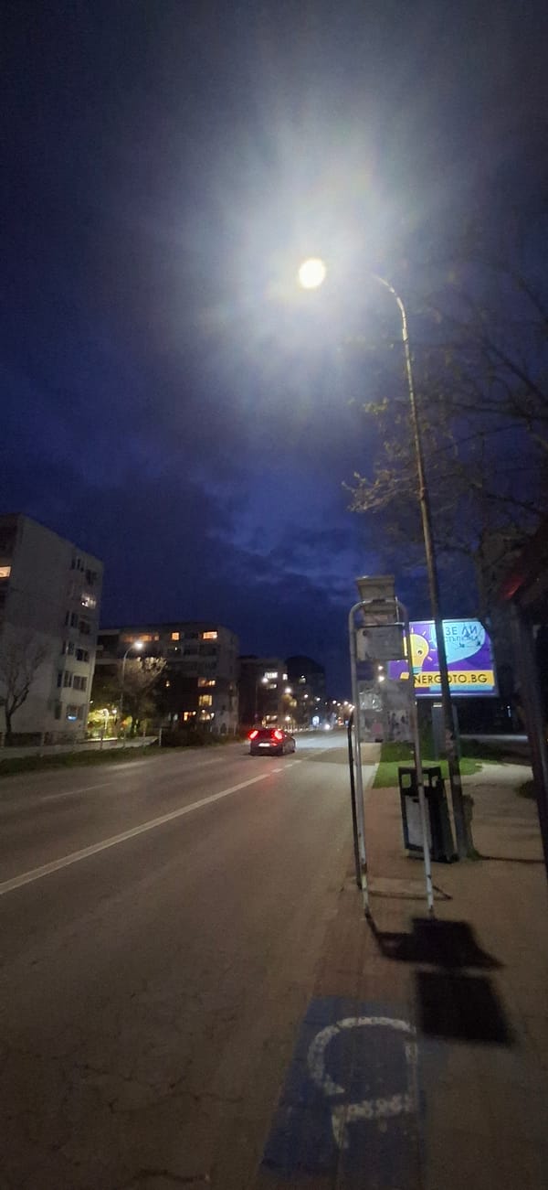 Nighttime urban street scene with moving vehicle captured