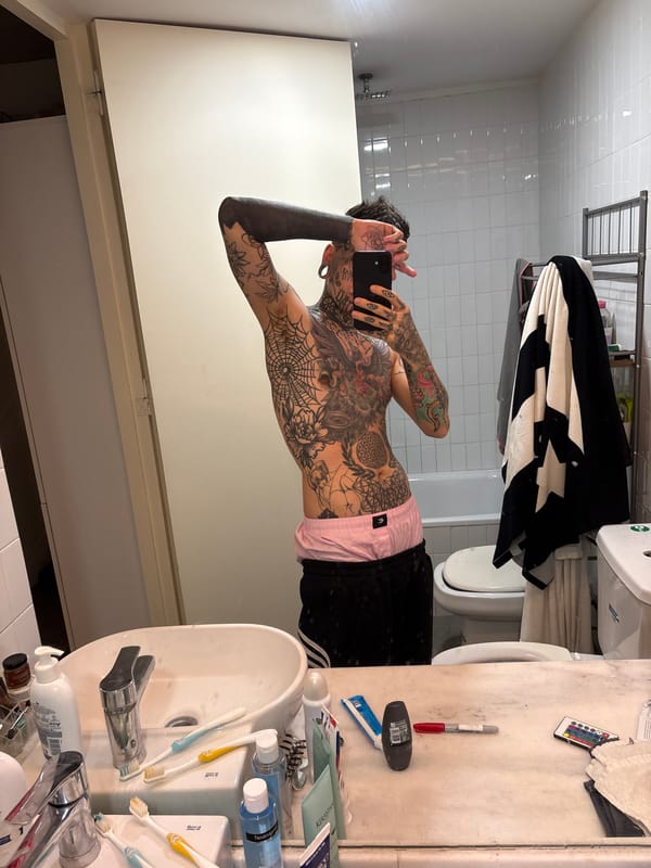 Tattooed individual takes multiple selfies in Buenos Aires residence