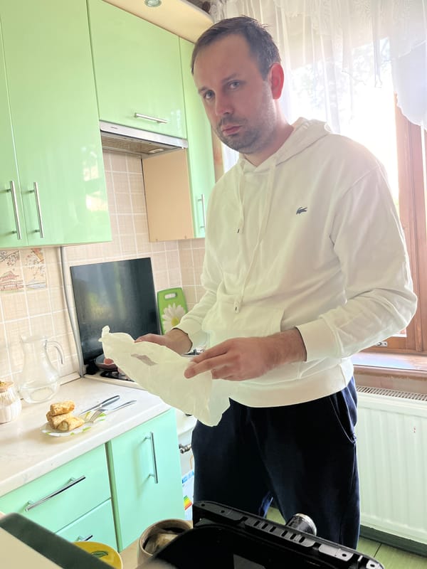 Man with paper observed in kitchen, Rusanovo, Russia