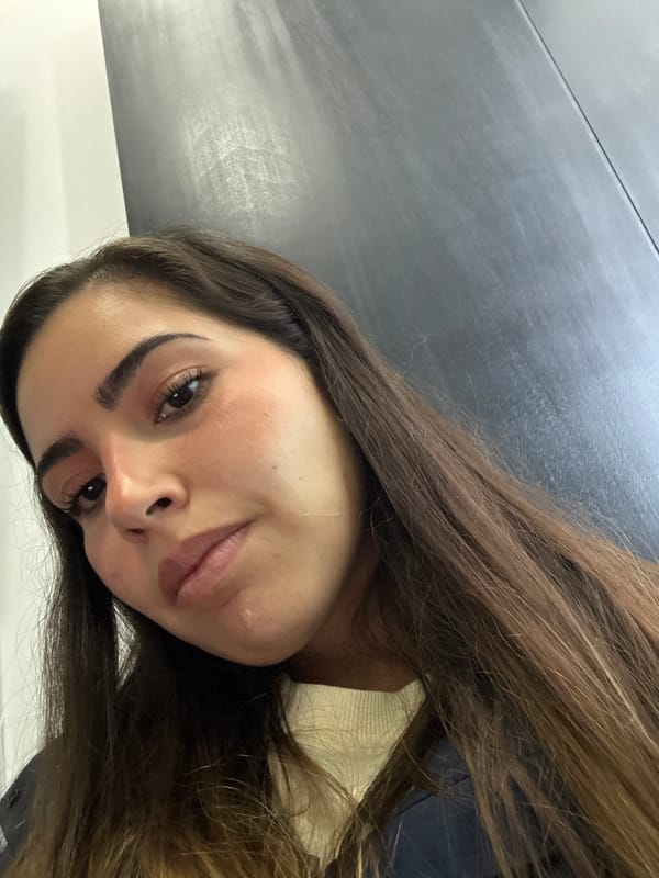 Woman takes selfie while someone uses laptop in Mexico