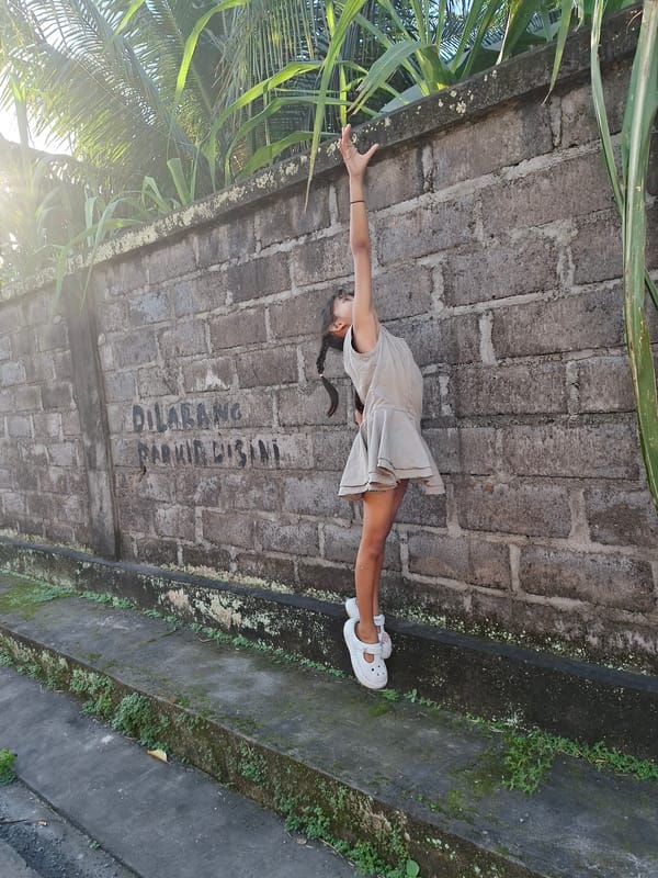 Child plays amid traditional Balinese architecture and tropical setting