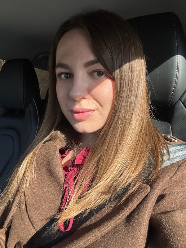 Woman in brown coat observed in car backseat