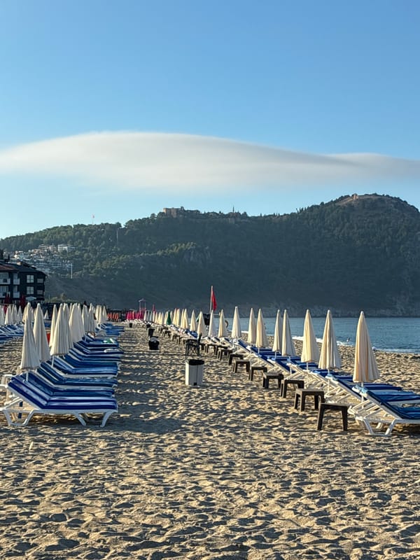 Empty beach chairs and long shadows on an Alanya shoreline