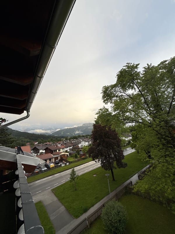 Couple smokes, photographs Alps from German balcony