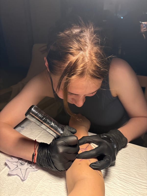 Tattoo artist works on forearm design in Ramat Gan