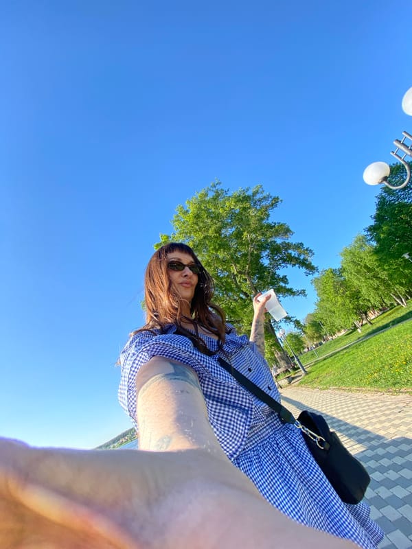 Woman enjoys cold drink during sunny park outing in Votkinsk