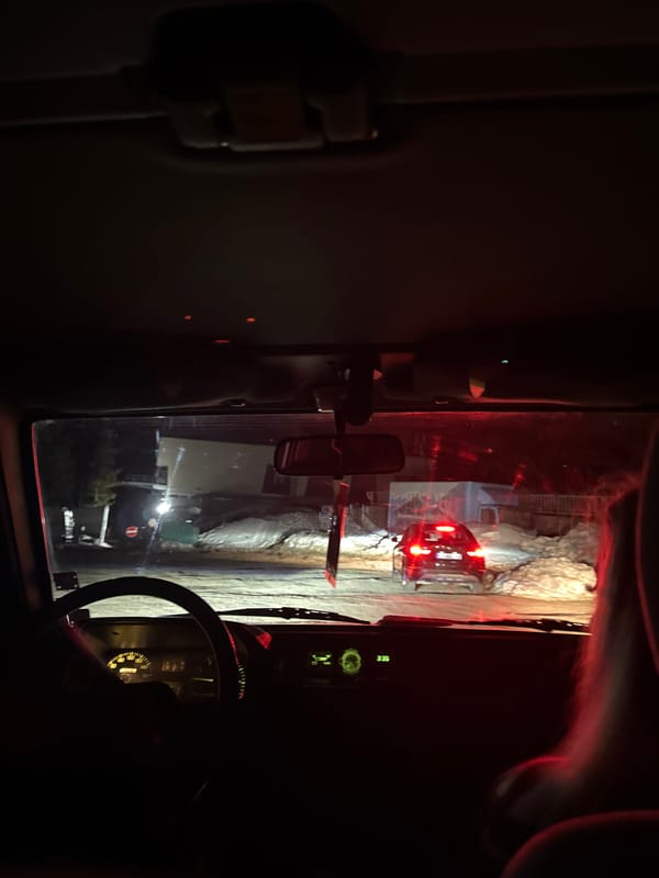 Night vehicle passes illuminated rock formation in Bistritsa, Bulgaria