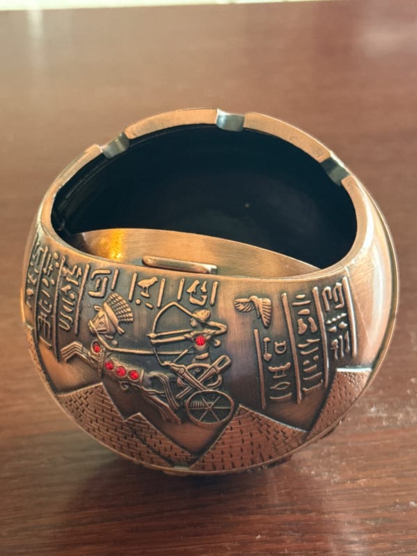 Close-up catalog shoot of Egyptian metal souvenirs and figurines