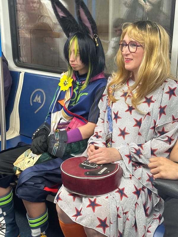 Costumed subway rider and street guitarist, same moment