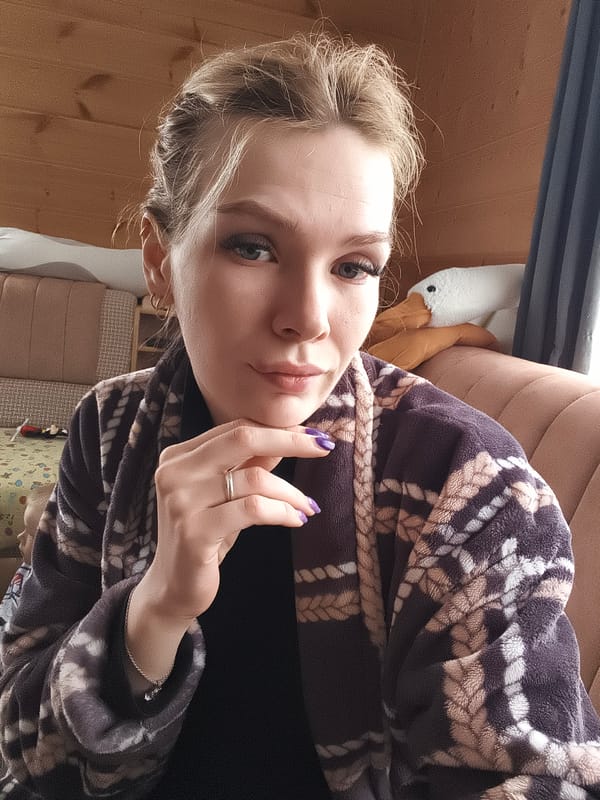 Woman in patterned robe sits on couch in Russia