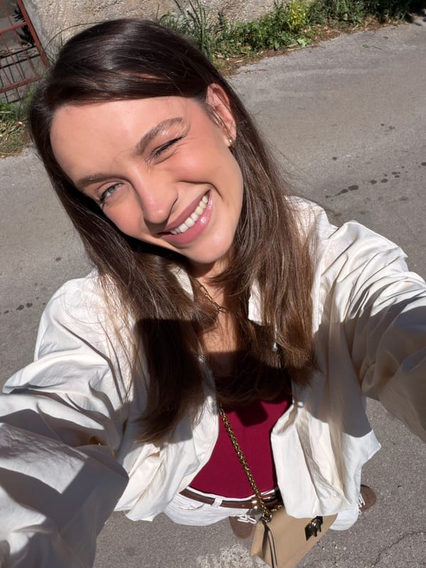Woman films selfies on sunny streets in Budva, Montenegro