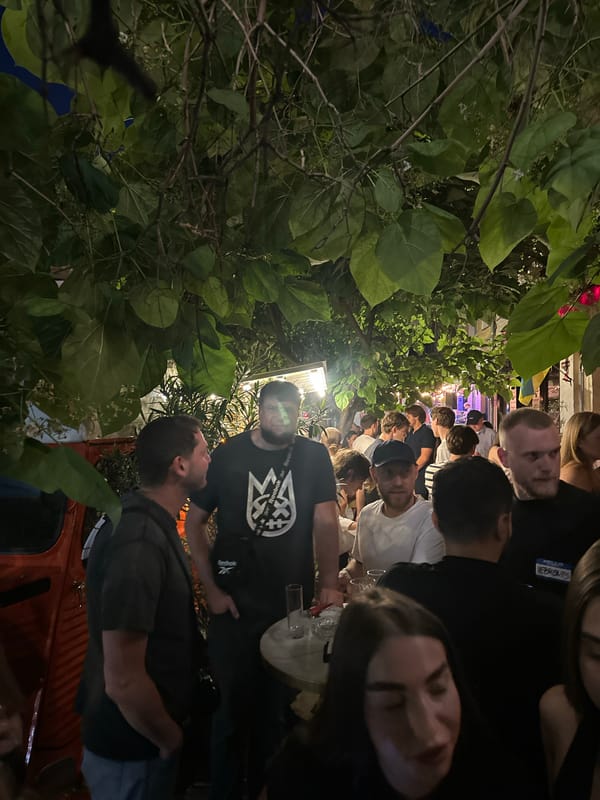 Lively nighttime bar patio gathering with crowds and ambient lighting