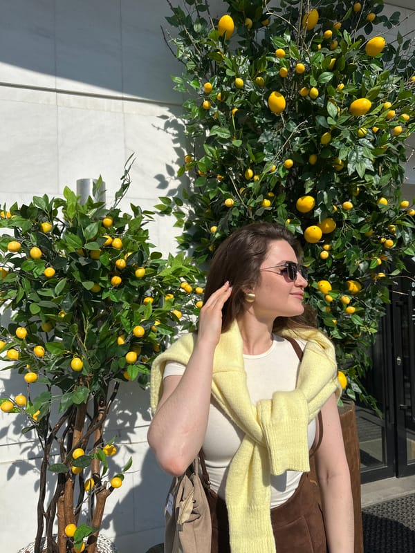 Woman rests on bench among lemon trees in Ufa