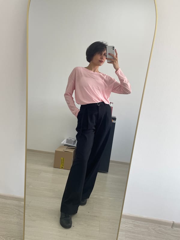Person takes mirror selfie in Izhevsk wearing pink shirt