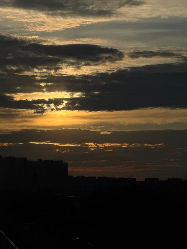 Sunset observed over Nizhny Novgorod skyline with layered clouds
