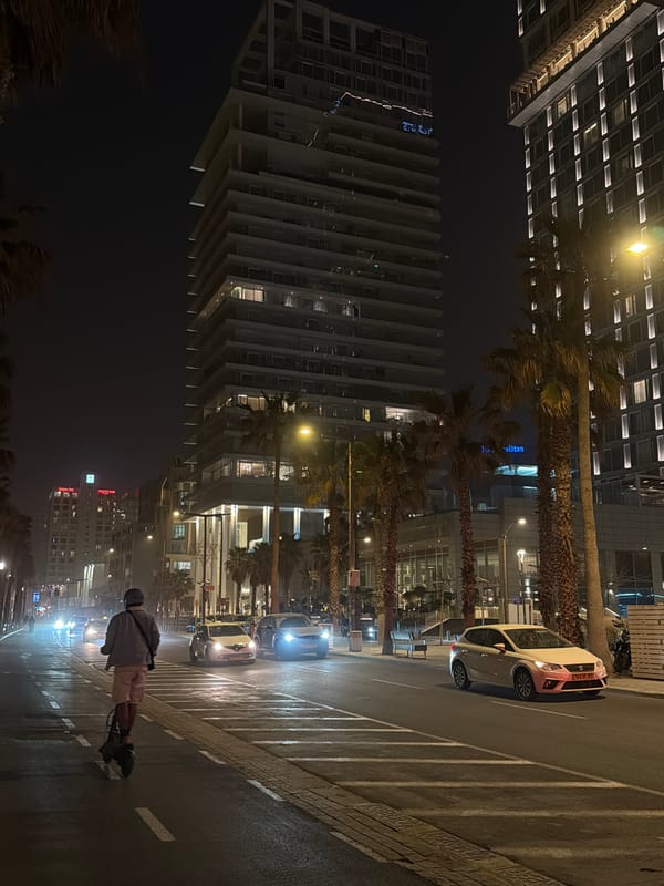 Roller skater travels streetlit Tel Aviv road at night