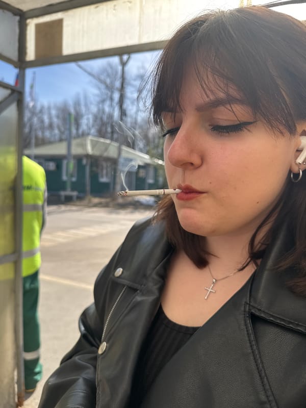 Woman smoking cigarette captured in Dmitrov street moment
