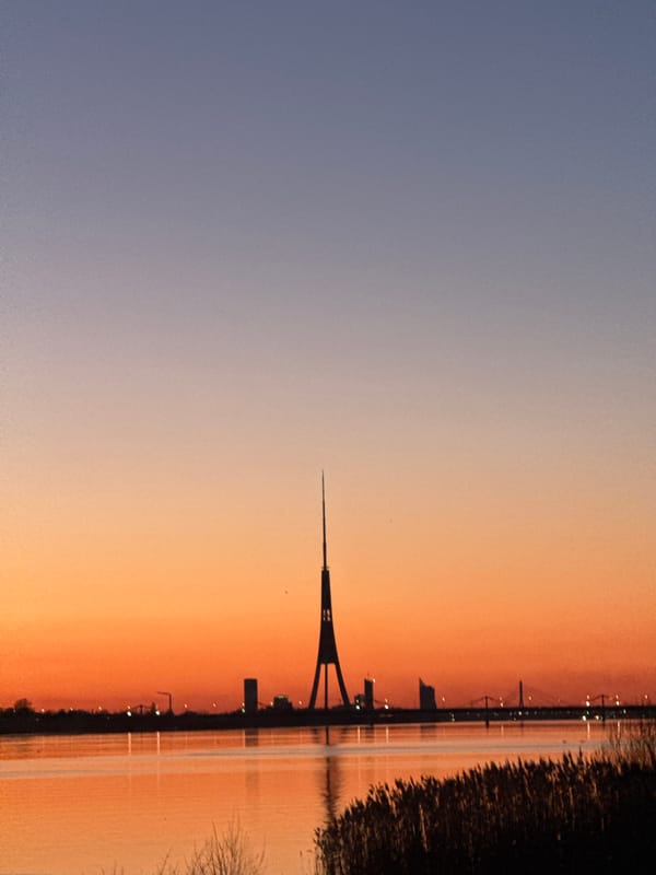 Sunset silhouettes Riga's iconic TV tower over Daugava River
