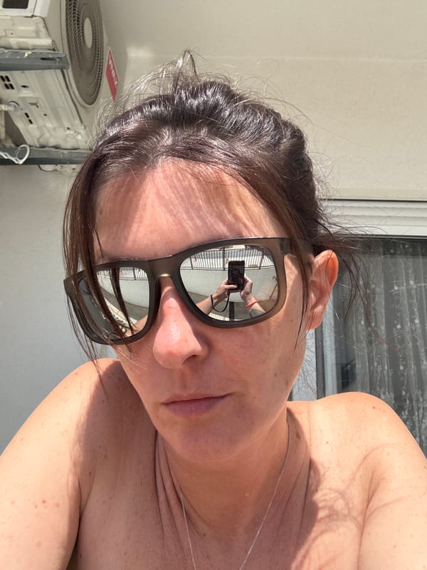 Tourist captures sunglasses selfies reflecting Bar cityscape