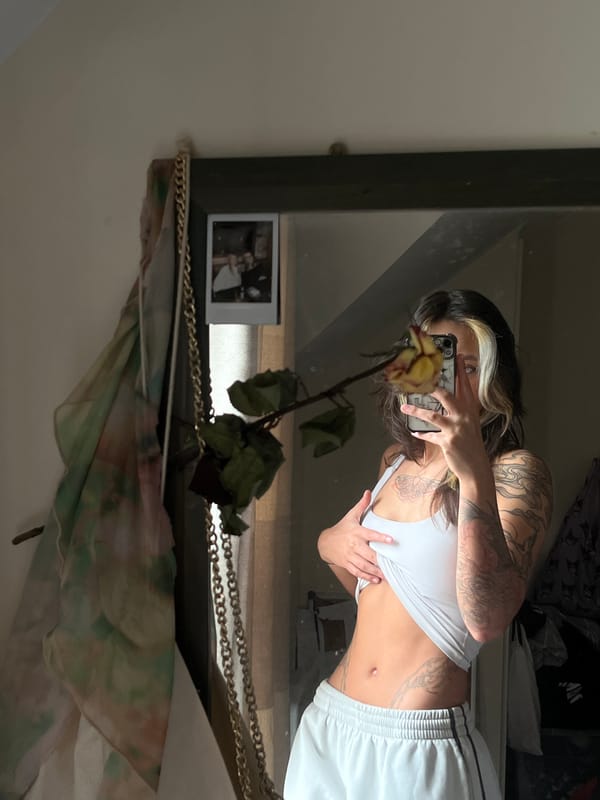 Woman takes mirror selfie with wilting rose in Tunbridge Wells