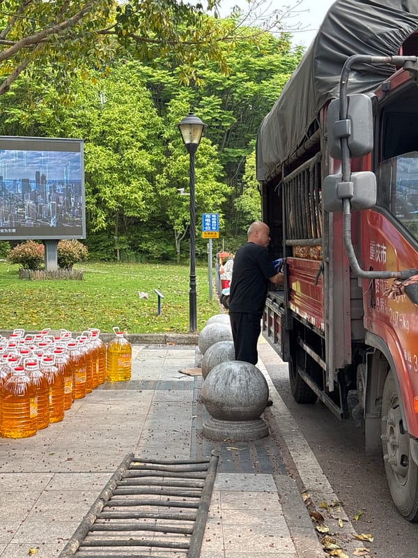 Man repairs red truck on sidewalk in Jiangjin