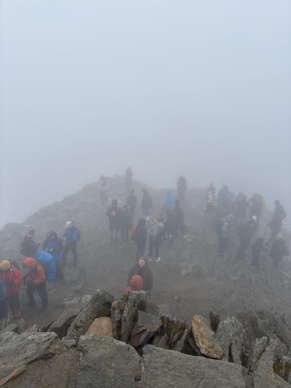 Hikers navigate foggy mountain paths near Beddgelert, Wales