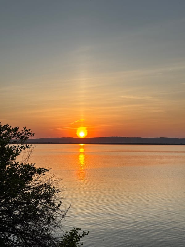 Woman enjoys riverside sunset in Chaikovsky, Russia