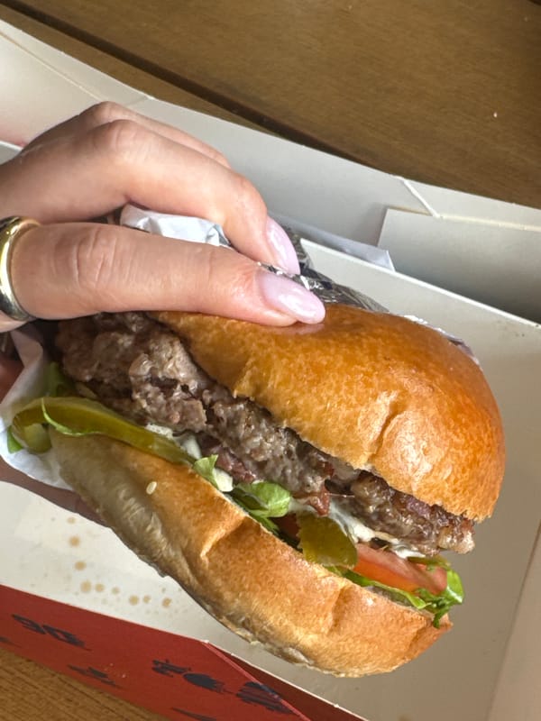 Partially eaten hamburger documented in takeout container