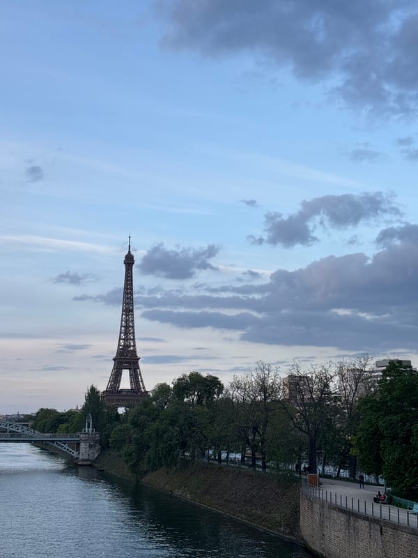 Eiffel Tower photographed from Seine River amid cloudy skies