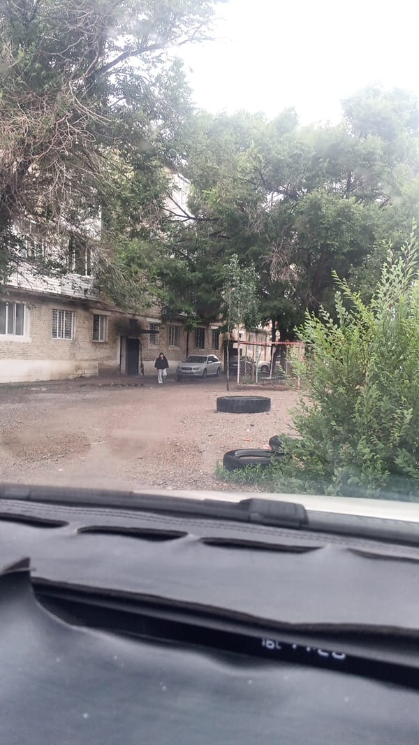 Wet streets and apartment blocks in Balykchy on a grey day