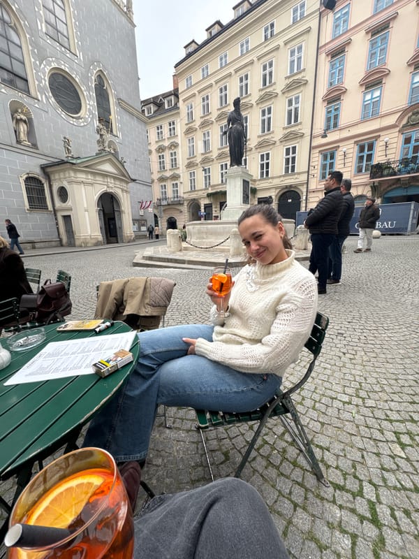 Woman enjoys orange drink at outdoor Vienna cafe