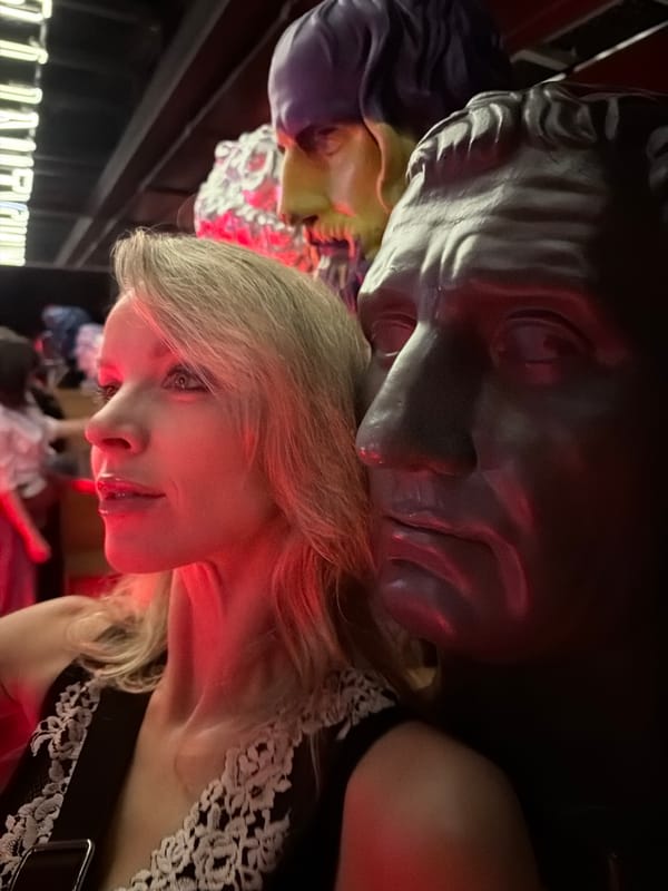 Woman leans against classical bust under red lighting in Moscow