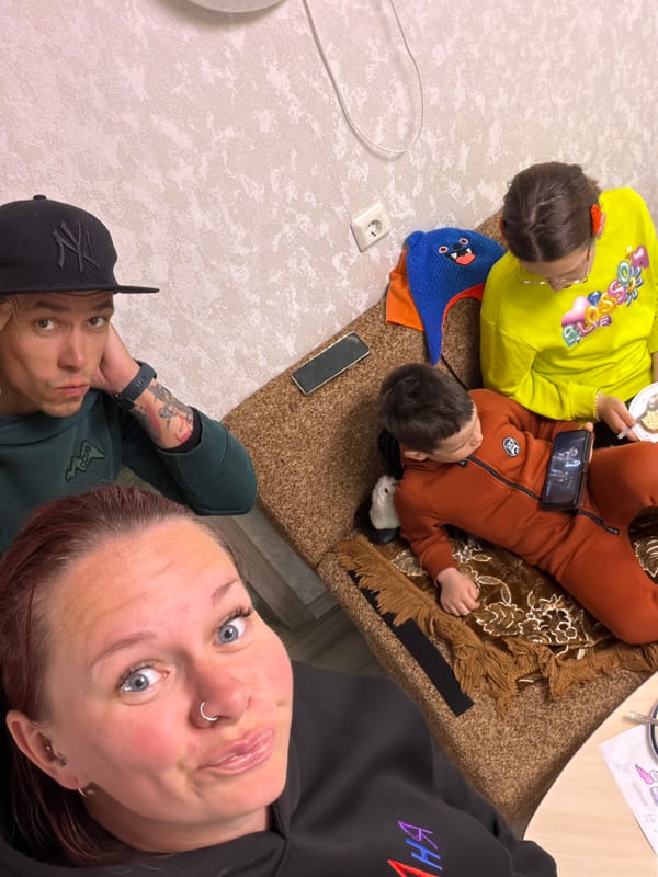 Four people gather indoors in Chaikovsky, children on rug